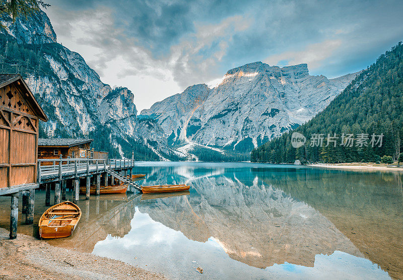 划艇在拉戈迪布雷斯(Pragser wildsee)平静的水面上倒影，这是意大利白云石山脉的一个令人惊叹的高山湖泊。